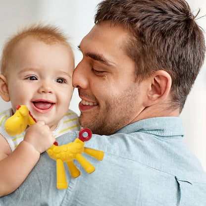 bebe dans les bras de son papa jou avec Anneau de dentition giraffe