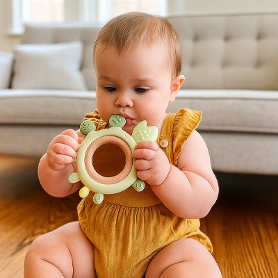  bébé fille met un Anneau de dentition vert dans sa bouche